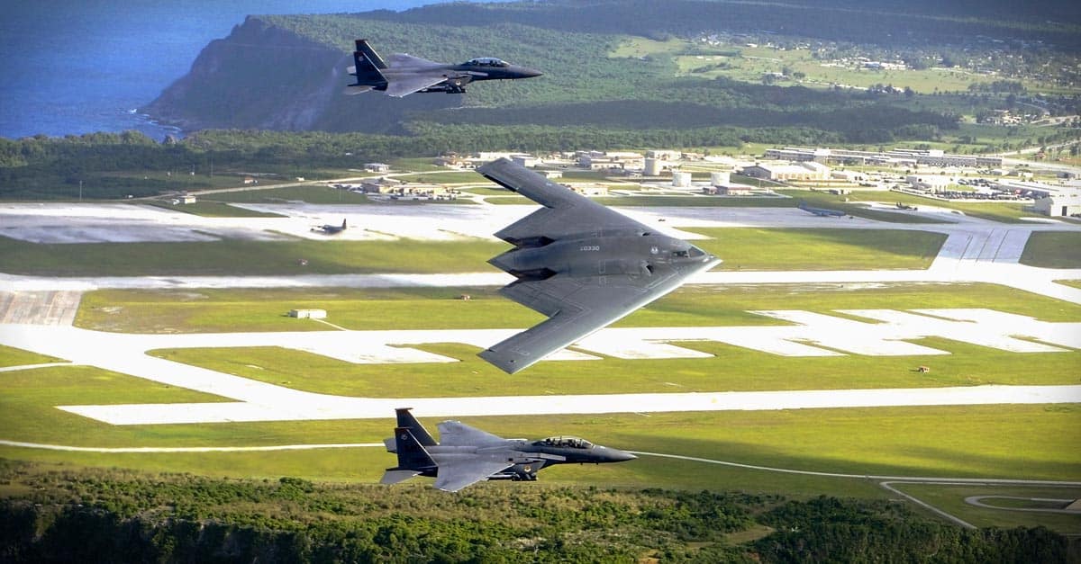 B-2_F-15E Strike Eagles and a B-2 Spirit bomber fly in formation over the base